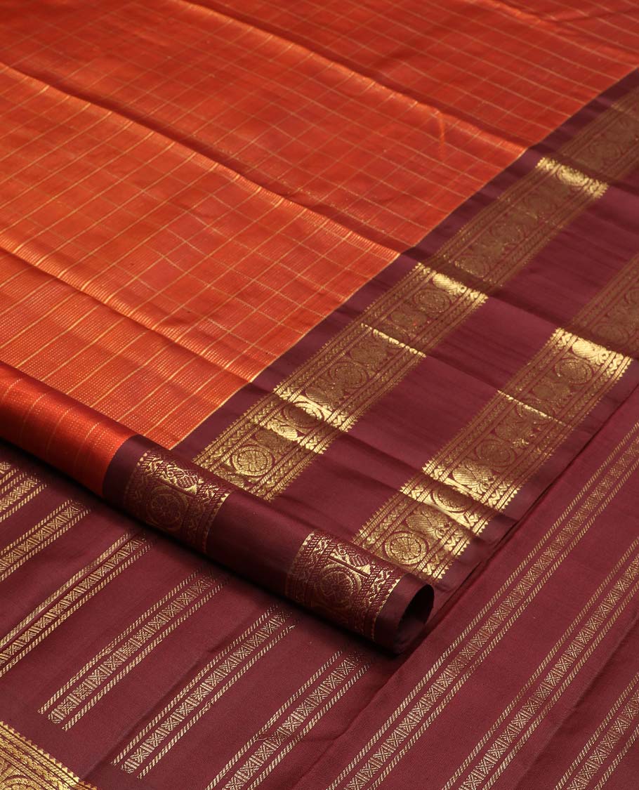 Orange zari checked Kanchipuram silk saree, contrast rettai pettu border of rekku, banaras, neli, and mayil chakram designs, and pallu of lavangam designs