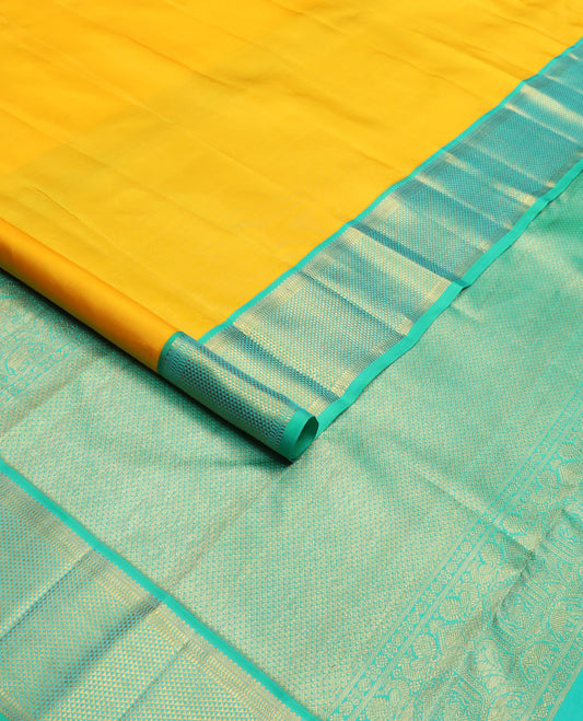 Yellow plain Kanchipuram silk saree, contrast border of salngai, muthu, and ara maadam designs, and intricate pallu