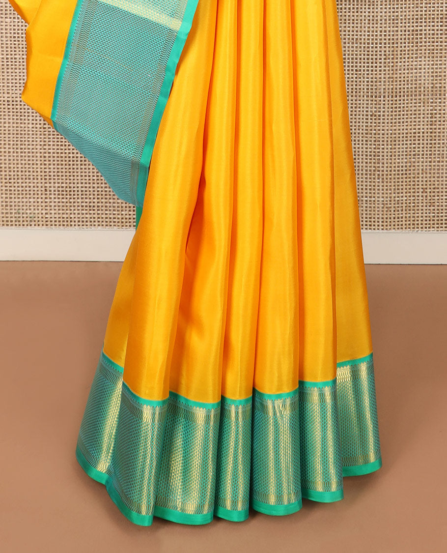 Yellow plain Kanchipuram silk saree, contrast border of salngai, muthu, and ara maadam designs, and intricate pallu