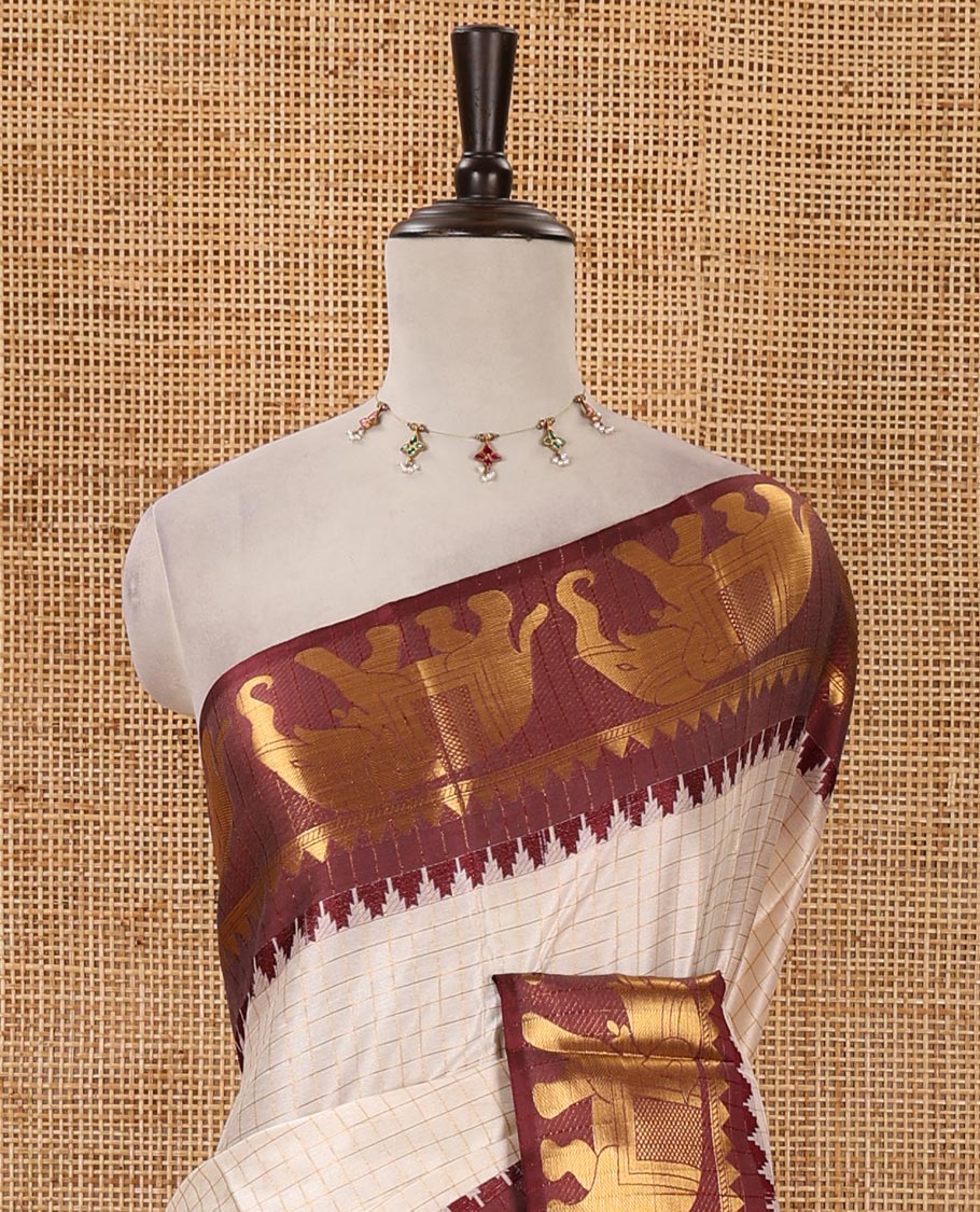 White checked semi-tafeta saree, contrast maroon temple zari elephant motifs border, zari-rich pallu & contrast checked zari border blouse