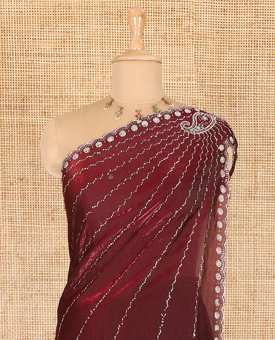Maroon micro-stone work fendy chiffon saree with paisley stone work on its shoulder, a scallop stone work border, a butterfly style pallu, and a matching stone work blouse