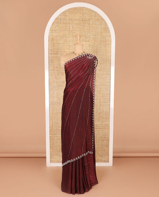 Maroon micro-stone work fendy chiffon saree with paisley stone work on its shoulder, a scallop stone work border, a butterfly style pallu, and a matching stone work blouse