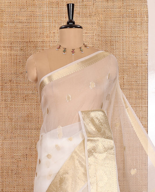 Half-white zari butta semi-organza saree, traditional zari design border of floral creeper designs, zari striped pallu, and a matching blouse