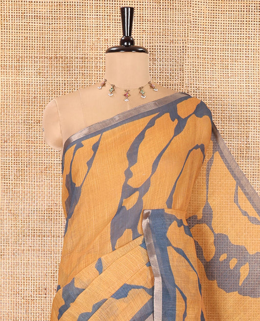 Mustard Linen Cotton Saree, Adorned with Shibori Prints on Its Body, Subtle Contrast Piping Border, Pallu of Floral Print, and Paired with a Matching Blouse