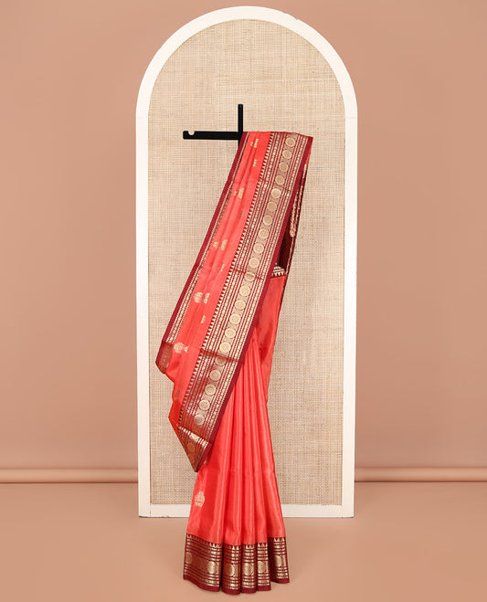 Orange Venkatagiri Silk Saree, Enthralled with Zari Buttas on Its Body, Complemented by a Contrast Traditional Zari Design Border, Pallu Depicts Floral and Zig-Zag Strip Designs, and Paired with a Contrast Blouse