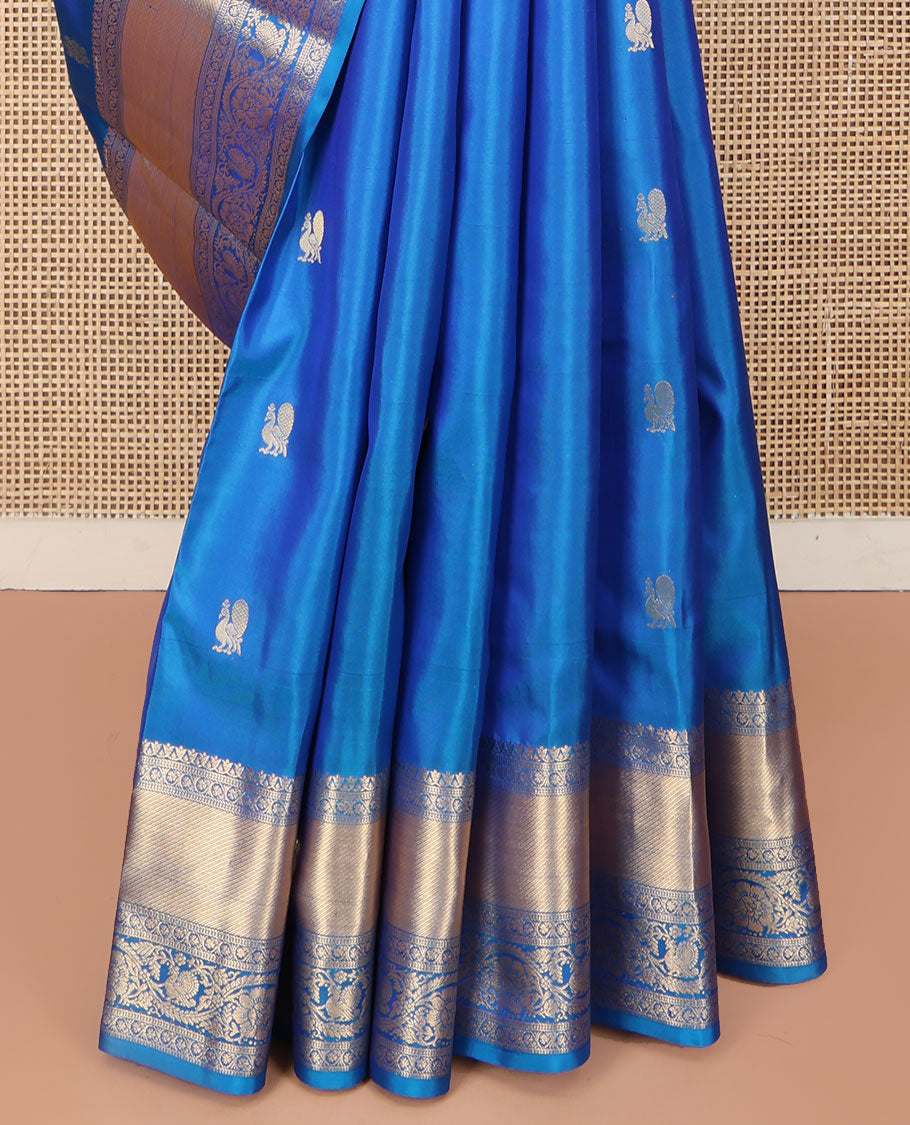 Blue Vasundhara Silk Saree, Mesmerized with Zari Buttas All Over Its Body, Highlighted by a Zari Border of Kodi Visiry, and Mayil Designs, Grand Jaal Pallu, and Paired with a Matching Blouse