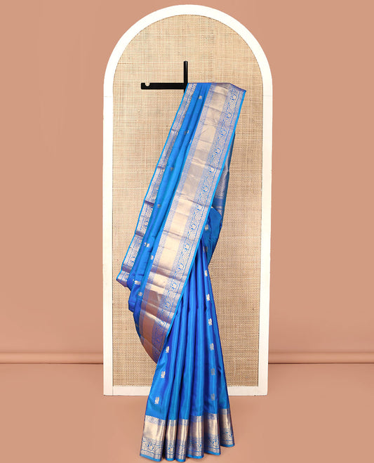 Blue Vasundhara Silk Saree, Mesmerized with Zari Buttas All Over Its Body, Highlighted by a Zari Border of Kodi Visiry, and Mayil Designs, Grand Jaal Pallu, and Paired with a Matching Blouse