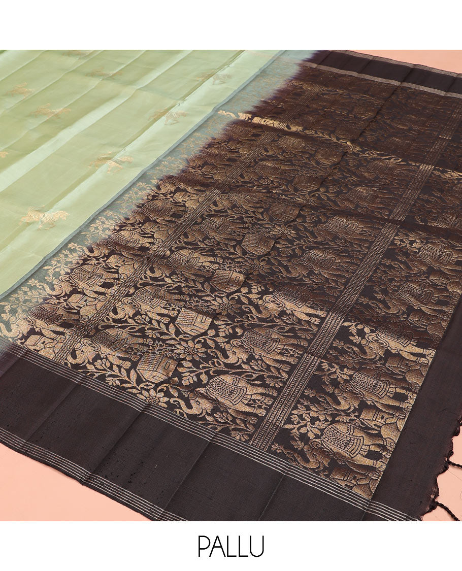 Green yaanai buttas soft silk saree, zari striped border, and contrast yaanai and house motifs woven pallu