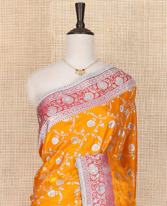 Orange Semi-Banaras Nylon Saree Highlighted with Floral Jaal Jacquard and Stone Work, Complemented by a Contrast Floral Creeper Zari Stone Work Lace Border, Floral Bouquets Themed Pallu Detailed in Zari and Stone Work, and Paired with a Contrast Blouse