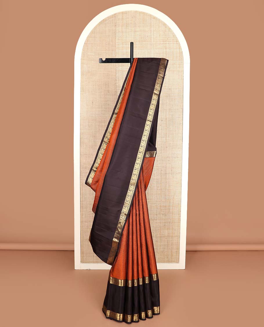 Orange micro-zari checked Kanchipuram silk saree, contrast rettai pettu border of thilakam mokku, rudraksham, and poo chakram and mayil designs, and buttas enclosed jaal pallu