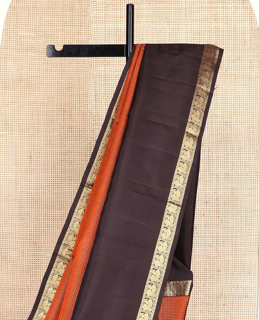 Orange micro-zari checked Kanchipuram silk saree, contrast rettai pettu border of thilakam mokku, rudraksham, and poo chakram and mayil designs, and buttas enclosed jaal pallu