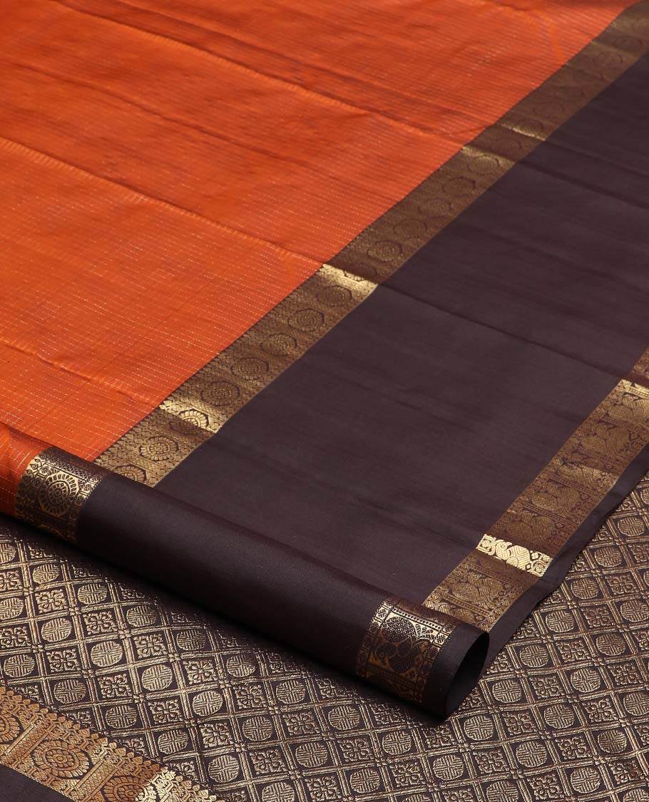 Orange micro-zari checked Kanchipuram silk saree, contrast rettai pettu border of thilakam mokku, rudraksham, and poo chakram and mayil designs, and buttas enclosed jaal pallu