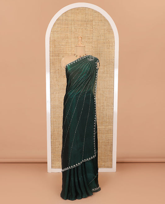 Green micro-stone work fendy chiffon saree with paisley stone work on its shoulder, a scallop stone work border, a butterfly style pallu, and a matching stone work blouse
