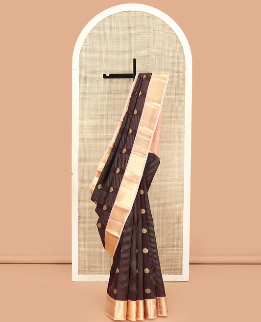 Brown Vasundhara Lite Silk Mix Saree, Prettified with Stripes, and Chakram Buttas, Complemented by a Contrast Border of Thilakam Mokku, Muthu, Banaras, Neli, and Mayil Designs, Pallu Steeped with Peacock Feather Designs, and Paired with a Contrast Blouse