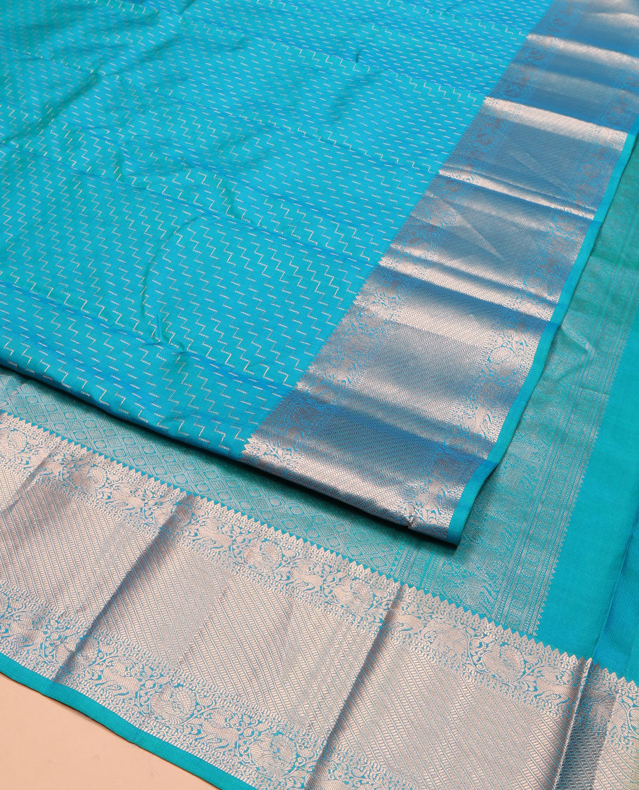 Blue Vasundhara Silk Saree, Beautifully Bedecked with Zig-Zag Stripes All Over Its Body, Highlighted by a Zari Border of Rekku, Muthu, Neli, Mayil, and Yaali Designs, Grand Jaal Pallu, and Paired with a Matching Blouse