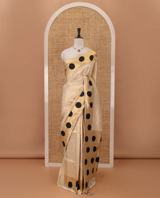 Cream golden zari striped banarasi tissue saree, zari vanki border & pallu of small black polka dot designs, plain blouse