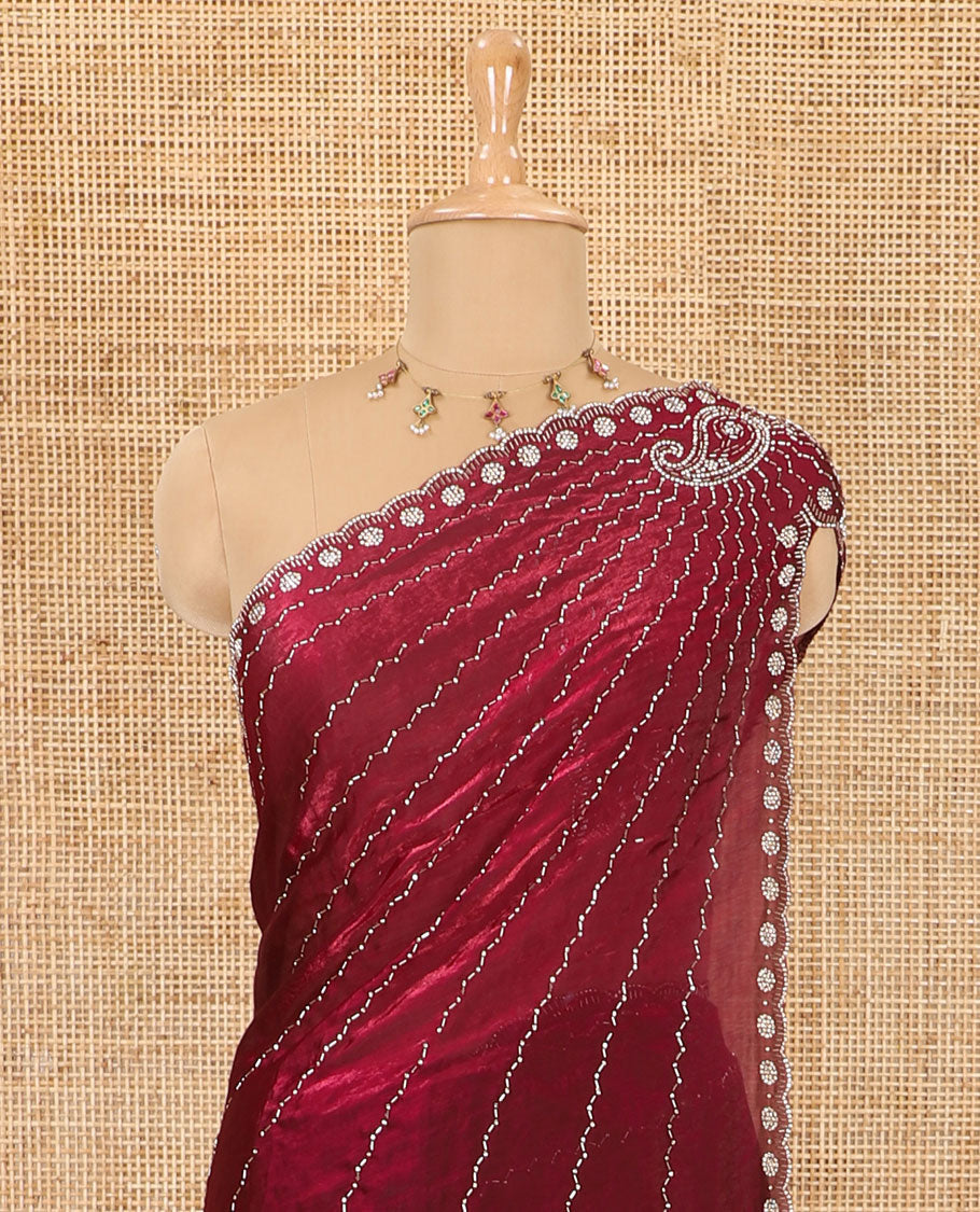 Red micro-stone work fendy chiffon saree with paisley stone work on its shoulder, a scallop stone work border, a butterfly style pallu, and a matching stone work blouse