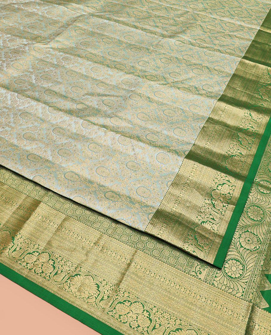 Green Kanchipuram Silk Saree Embellished with Jacquard Design, Highlighted by a Contrast Border of Thilakam, Muthu, Rekku, Manga, Chakram, and Floral Designs, Majestically Woven Pallu Steeped with Chakram Designs, and Paired with a Matching Blouse