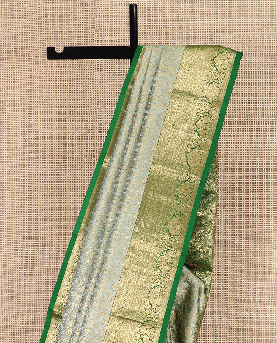 Green Kanchipuram Silk Saree Embellished with Jacquard Design, Highlighted by a Contrast Border of Thilakam, Muthu, Rekku, Manga, Chakram, and Floral Designs, Majestically Woven Pallu Steeped with Chakram Designs, and Paired with a Matching Blouse
