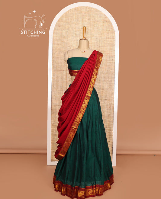 Green cotton half-saree, plain with contrast elephant motif bordered skirt, matching blouse, and contrast elephant motif bordered dhavani