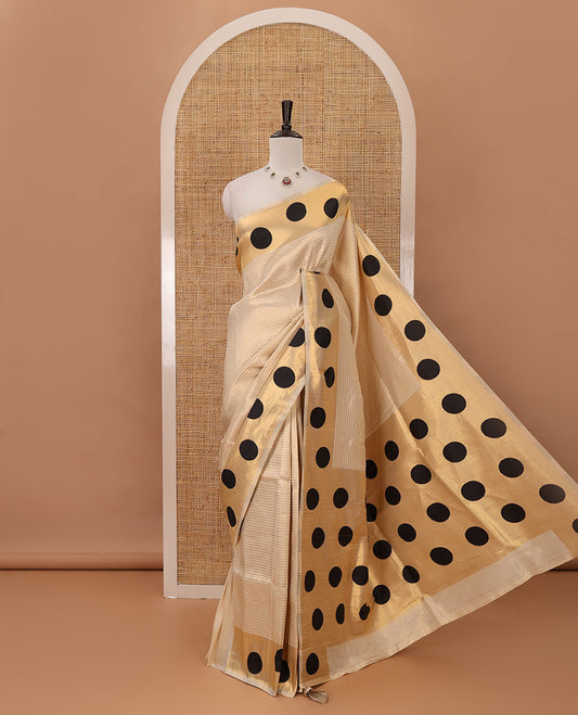 Cream golden zari striped banarasi tissue saree, zari vanki border & pallu of small black polka dot designs, plain blouse