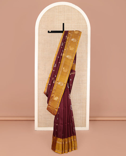 Maroon Uppada Silk Saree, Ornamented with Zari Buttas All Over Its Body, Complemented by Contrast Zari Border of Floral Designs, Pallu Steeped with Floral Designs, and Paired with a Contrast Blouse