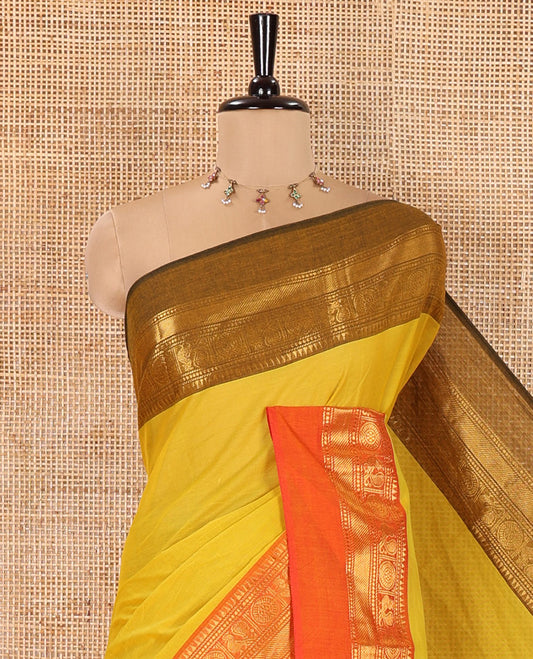 Yellow Plain Chettinad Cotton Saree, Complemented by Contrast Traditional Zari Design Ganga-Jamuna Border of Peacock-Chakram Designs, Subtly Striped Pallu, and Paired with a Matching Blouse
