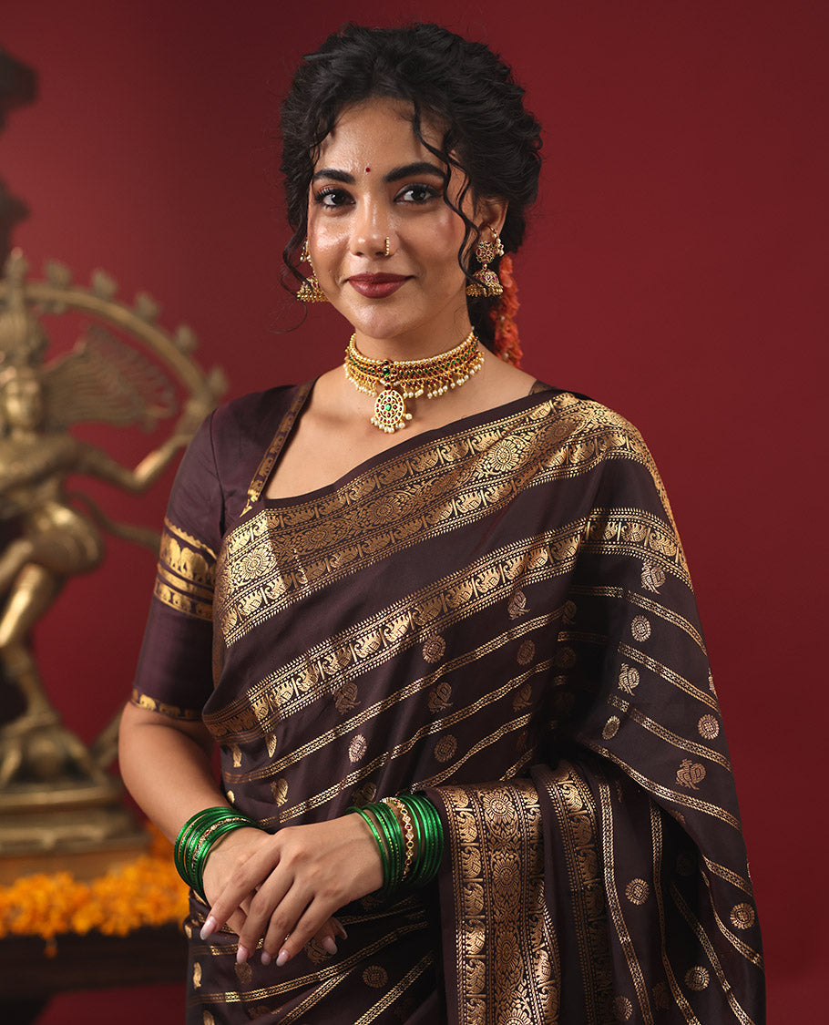 Brown Vasundhara Silk Saree, Enriched with Annam Chakram Buttas and Zari Stripes, Highlighted by Zari Rettai Pettu Border of Ara Bogudi, Muthu, Banaras, Yaanai, and Chakram Designs, Gleaming Jaal Design Woven Pallu, and Paired with a Matching Blouse