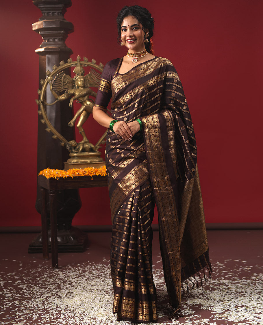 Brown Vasundhara Silk Saree, Enriched with Annam Chakram Buttas and Zari Stripes, Highlighted by Zari Rettai Pettu Border of Ara Bogudi, Muthu, Banaras, Yaanai, and Chakram Designs, Gleaming Jaal Design Woven Pallu, and Paired with a Matching Blouse