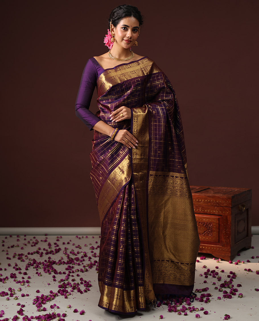Purple Vasundhara Silk Saree Spotlighted with Zari Butta Enclosed Checks, Highlighted by a Zari Border of Kuthirai and Chakra Designs, Pallu Complemented by Zari Rich Weave, and Paired with a Matching Blouse