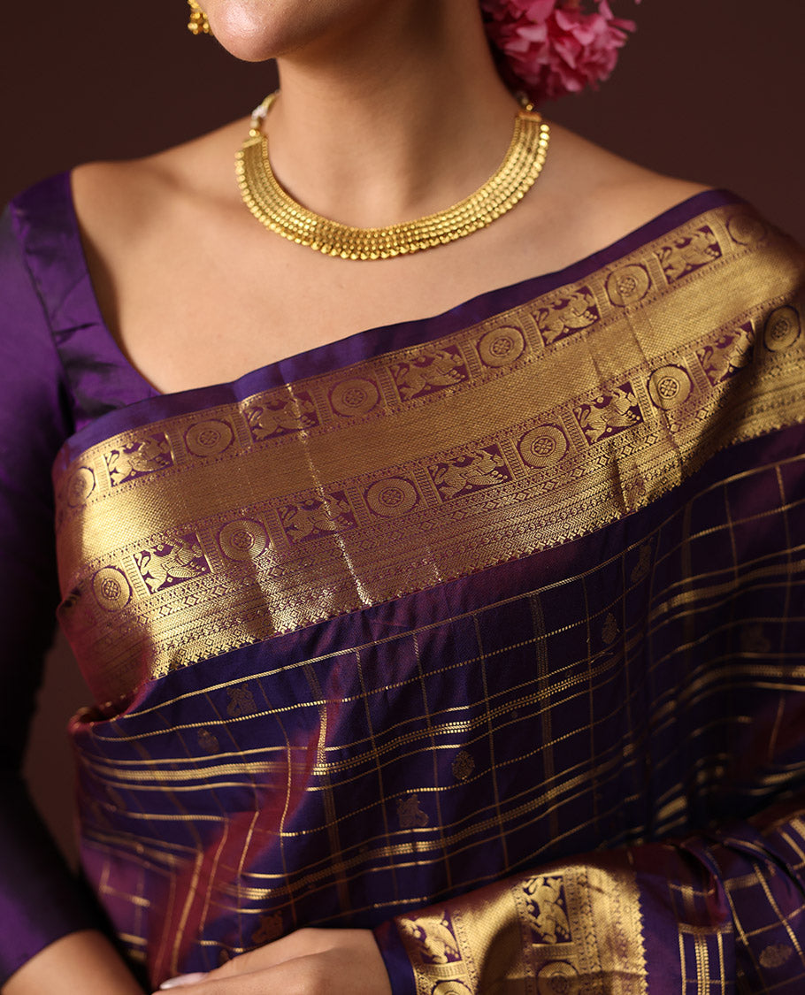 Purple Vasundhara Silk Saree Spotlighted with Zari Butta Enclosed Checks, Highlighted by a Zari Border of Kuthirai and Chakra Designs, Pallu Complemented by Zari Rich Weave, and Paired with a Matching Blouse