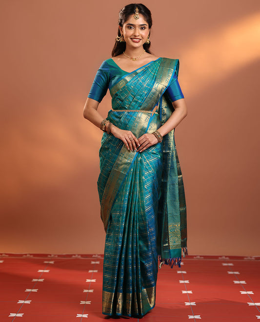 Peacock Blue Vasundhara Silk Saree Gleamed Up with Zari Buttas Enclosed in Zari Checks, Featuring a Zari Border of Kuthirai and Chakra Designs, Pallu Complemented by Rich Zari Weave, and a Matching Blouse