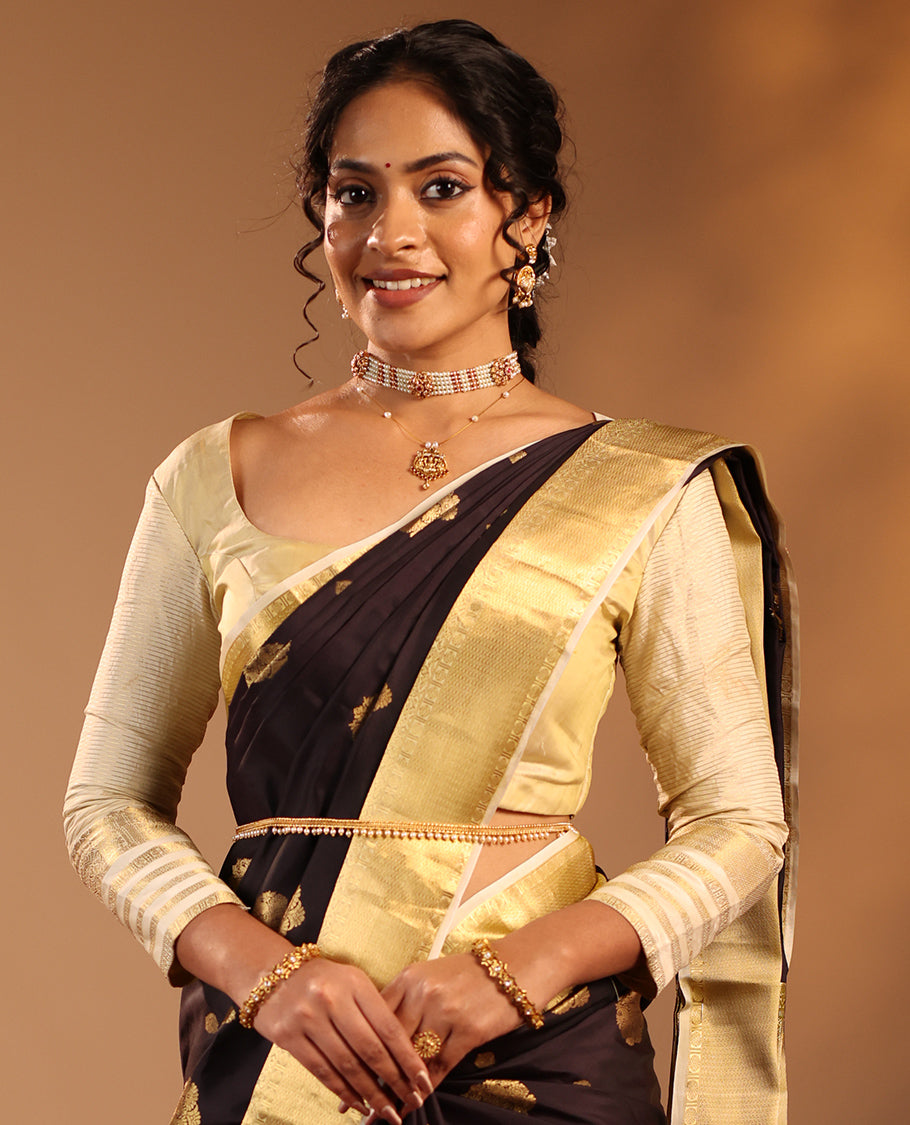 Dark Chocolate Brown Vasundhara Silk Saree Highlighted with Zari Buttas, Decked Up with a Contrast Border Featuring Rekku, Mayil Kann, Mayil, and Rudraksham Designs, Zari-Elevated Pallu, and Complemented with a Zari-Embellished Blouse