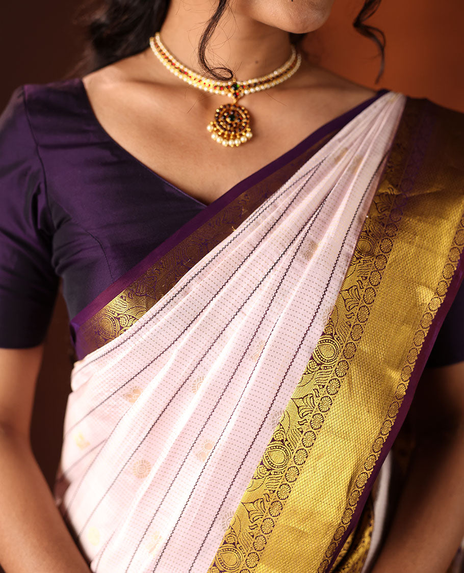 White silk saree adorned with Mayil Chakram, Neli, and Muthu stripes, featuring a contrast border with Laddu Kamalam, Mayil, Yaali, and Mayil Kann designs, along with a Jaal design pallu