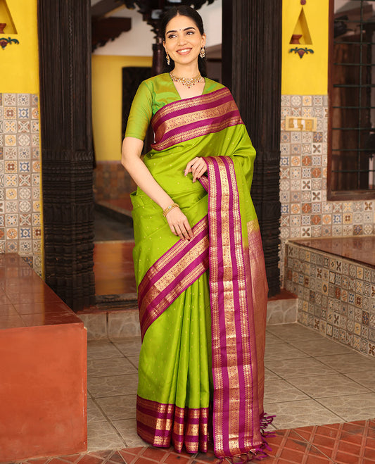 Parrot Green Vasundhara Silk Saree Richly Detailed with Zari Buttas, Complemented with Varisai Pettu Border Featuring Rekku, Muthu, Banaras, Rudraksham, and Mayil Designs, Majestically Zari Woven Pallu, and a Contrast Blouse
