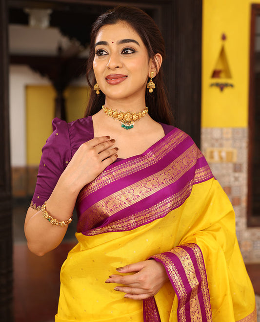 Yellow Vasundhara Silk Saree Finely Woven with Zari Buttas, Complemented with Varisai Pettu Border Featuring Rekku, Muthu, Banaras, Rudraksham, and Mayil Designs, Majestically Zari-Woven Pallu, and a Contrast Blouse