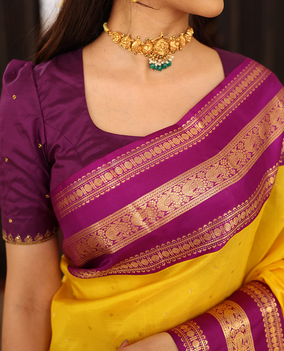 Yellow Vasundhara Silk Saree Finely Woven with Zari Buttas, Complemented with Varisai Pettu Border Featuring Rekku, Muthu, Banaras, Rudraksham, and Mayil Designs, Majestically Zari-Woven Pallu, and a Contrast Blouse