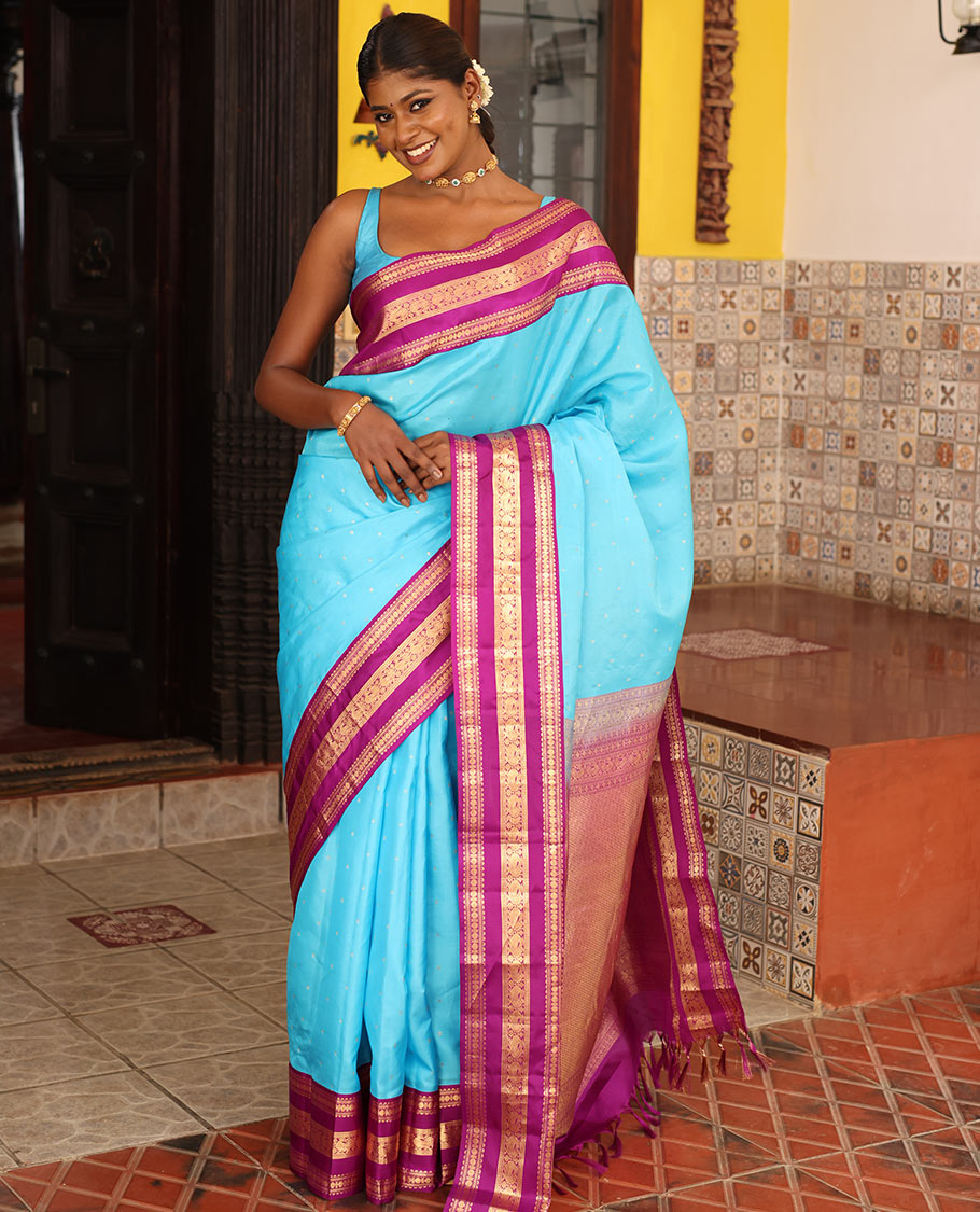 Blue Vasundhara Silk Saree Gracefully Embellished with Zari Buttas, Complemented by a Varisai Pettu Border Featuring Rekku, Muthu, Banaras, Rudraksham, and Mayil Designs, Majestically Woven with a Zari-Designed Pallu, and Paired with a Contrast Blouse