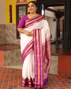 White Vasundhara Silk Saree Elegantly Embellished with Zari Buttas, Complemented by a Varisai Pettu Border Featuring Rekku, Muthu, Banaras, Rudraksham, and Mayil Designs, Majestically Woven with a Zari-Designed Pallu, and Paired with a Contrast Blouse