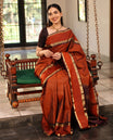 Rust Orange Mayuri Soft Silk Saree Graced with Medium-sized Zari Checks, Complemented by a Contrast Rettai Pettu Border of Rekku, Banaras, Kathir, and Star Vanki Designs, Pallu Elevated with Zari Designs, and Paired with a Contrast Blouse