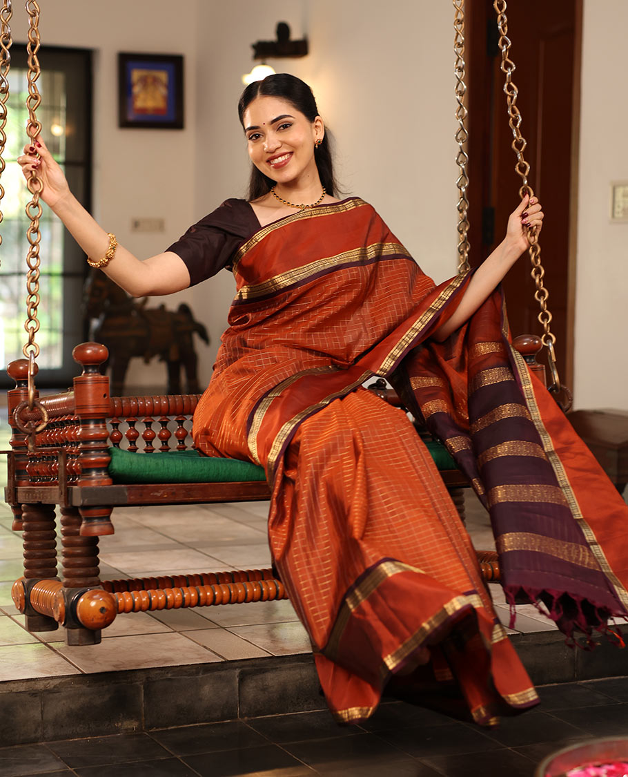 Rust Orange Kanchipuram Soft Silk Saree Graced with Medium-sized Zari Checks, Complemented by a Contrast Rettai Pettu Border of Rekku, Banaras, Kathir, and Star Vanki Designs, Pallu Elevated with Zari Designs, and Paired with a Contrast Blouse