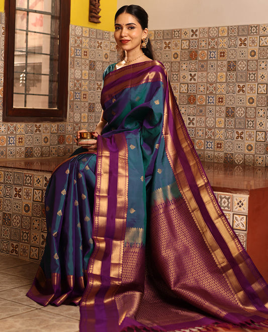 Blue Vasundhara Silk Saree Decked with Zari Buttas, Delicately Woven with a Contrast Rettai Pettu Border Featuring Thilakam Mokku, Vanki, Mayil Kann, and Star Motifs, a Majestically Woven Jaal-Designed Pallu, Paired with a Zari-Designed Blouse