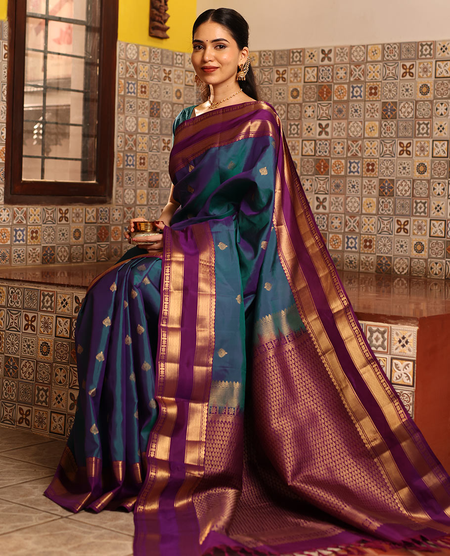 Blue Vasundhara Silk Saree Decked with Zari Buttas, Delicately Woven with a Contrast Rettai Pettu Border Featuring Thilakam Mokku, Vanki, Mayil Kann, and Star Motifs, a Majestically Woven Jaal-Designed Pallu, Paired with a Zari-Designed Blouse
