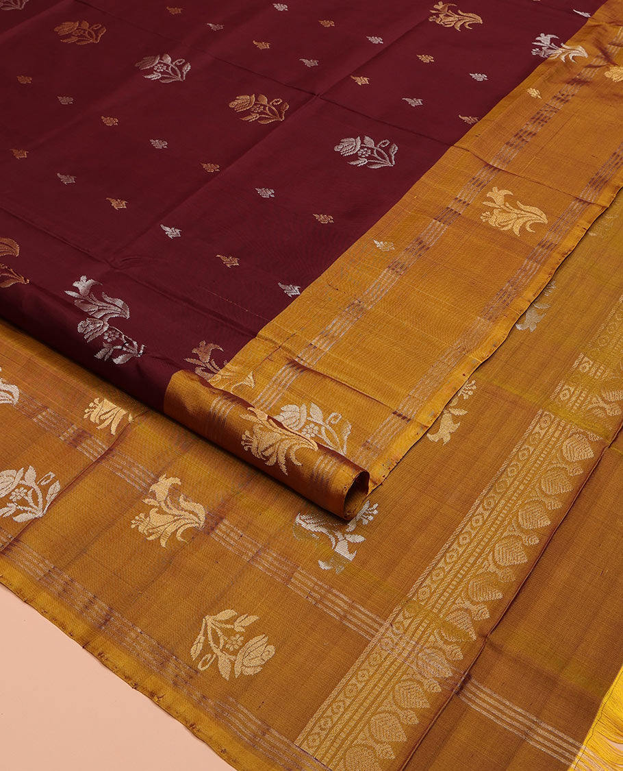 Maroon Uppada Silk Saree, Ornamented with Zari Buttas All Over Its Body, Complemented by Contrast Zari Border of Floral Designs, Pallu Steeped with Floral Designs, and Paired with a Contrast Blouse