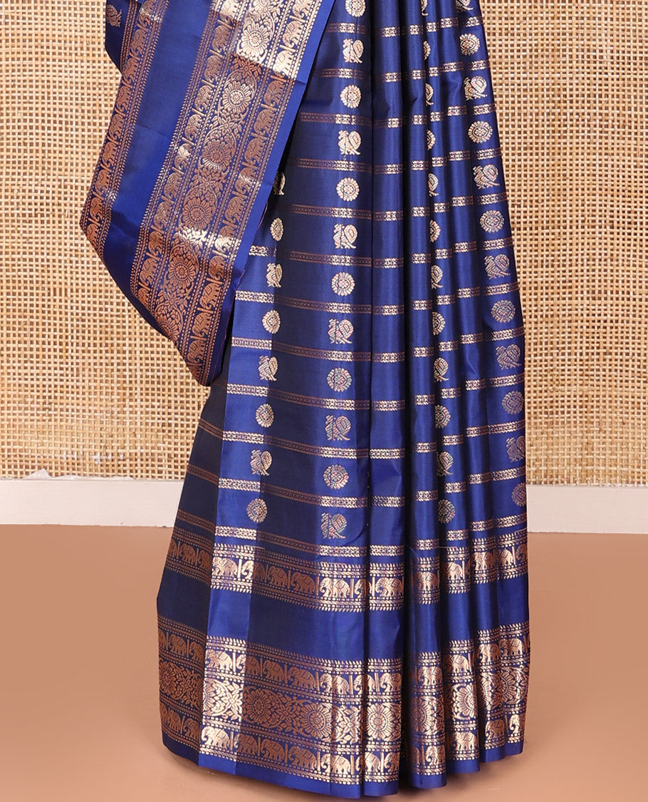 Blue Vasundhara Silk Saree Adorned with Zari Stripes and Annam Chakram Buttas, Highlighted by a Zari Border of Ara Bogudi, Muthu, Banaras, Yaanai, and Chakram Designs, a Zari-Woven Pallu of Jaal Designs, and Paired with a Matching Blouse
