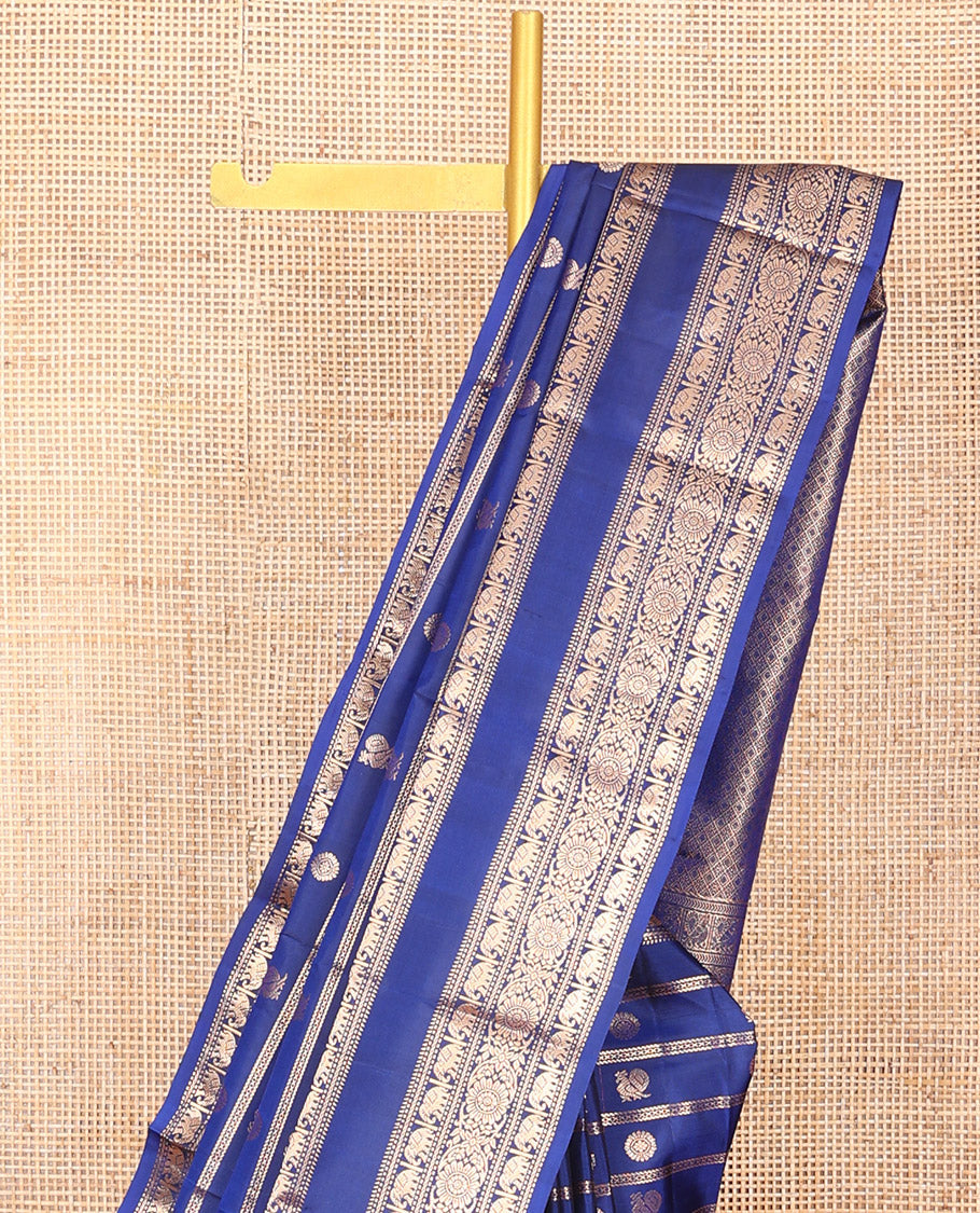 Blue Vasundhara Silk Saree Adorned with Zari Stripes and Annam Chakram Buttas, Highlighted by a Zari Border of Ara Bogudi, Muthu, Banaras, Yaanai, and Chakram Designs, a Zari-Woven Pallu of Jaal Designs, and Paired with a Matching Blouse