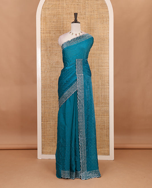 Rama blue Swarovski crystal stone embedded fendy chiffon saree, scallop Swarovski stone embroidered border, and contrast plain blouse