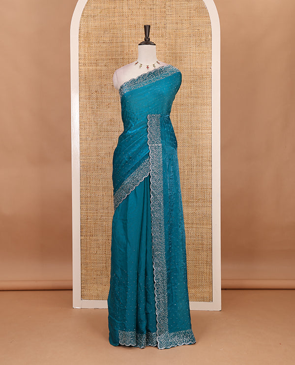 Rama blue Swarovski crystal stone embedded fendy chiffon saree, scallop Swarovski stone embroidered border, and contrast plain blouse