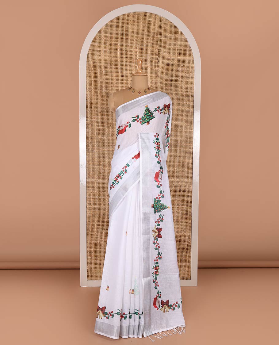 White jingle bell and Christmas tree motifs printed linen saree with bavanji borders, Santa Claus figure printed pallu, and a contrast jingle bell printed blouse