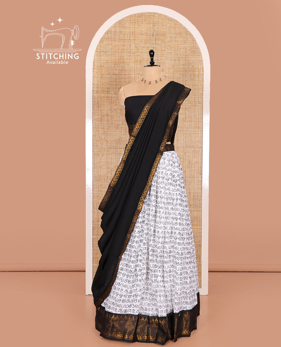 White and Black Printed Sungudi Cotton Half-Saree Showcasing a Skirt Printed with Tamil Letters, Accentuated by a Contrast Traditional Zari Border, a Contrast Blouse, and a Plain Zari-Bordered Dhavani